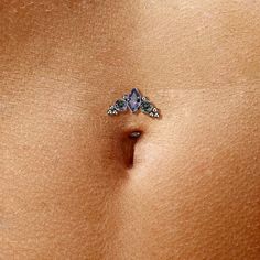 a woman's stomach with a piercing on it