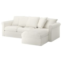 a white sectional couch with pillows on it's back and side ends, facing away from the camera