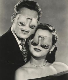 an old black and white photo of a man and woman with fake nose rings on their faces