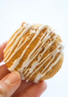 a hand holding a cookie with icing on it