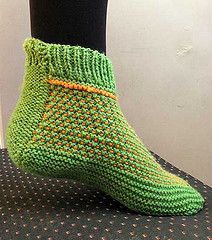 a pair of green socks sitting on top of a black table next to a white wall