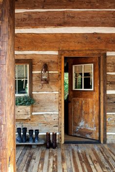 there are boots lined up on the porch by the door and in front of the house