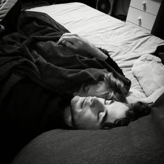 a man laying on top of a bed under a blanket