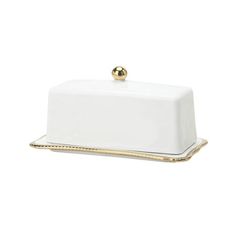 a white and gold platter with a golden beaded handle on the top,