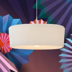 a chandelier hanging from the ceiling in front of colorful wallpaper and umbrellas