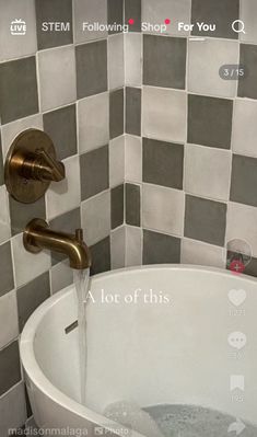 a white bath tub sitting under a faucet in a bathroom