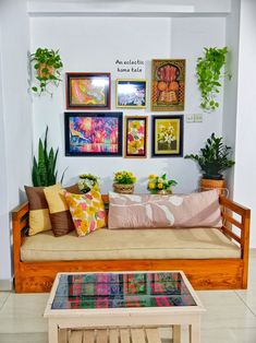 a living room filled with lots of furniture and plants on top of the couches