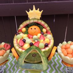 there is a watermelon fruit bowl with an orange and other fruits in it