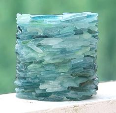 a glass vase sitting on top of a window sill filled with lots of rocks