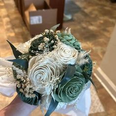 the bridal bouquet is made up of white roses and green succulents