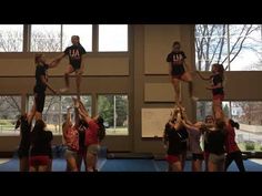 a group of people standing on top of each other in the middle of a gym