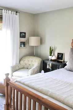 a white bed sitting next to a window in a bedroom