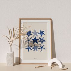 blue starfishs are arranged in a circle on a white background next to a plant