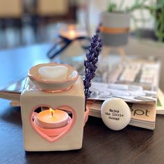 a candle holder sitting on top of a wooden table next to a plate with a heart