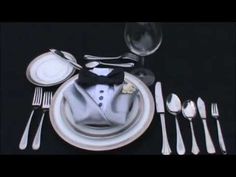 a table setting with silverware and utensils, including a tuxedo