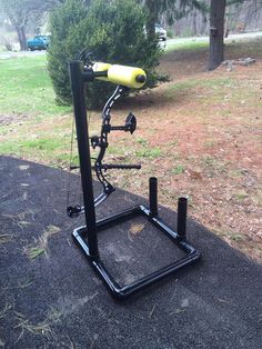 the bike stand is sitting on top of the ground in front of some grass and trees