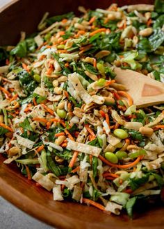 a salad in a wooden bowl with a wooden spoon