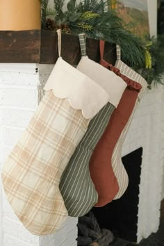 three stockings hanging from a fireplace mantel