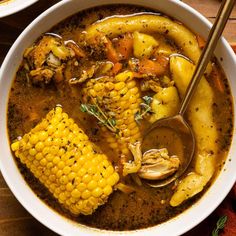 a white bowl filled with soup and corn on the cob