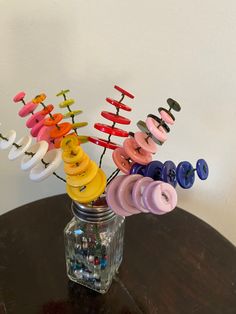 a vase filled with lots of different colored buttons