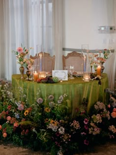 a table with flowers and candles on it