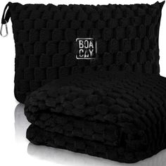 two black towels sitting next to each other on top of a white surface with the word boa clay printed on it