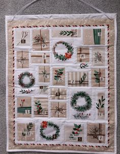 a quilted wall hanging with christmas wreaths on it