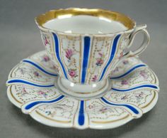 an antique tea cup and saucer with gold trim