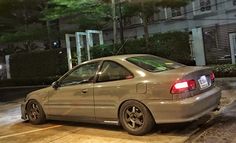 a silver car parked in front of a building at night