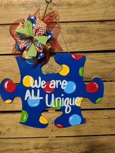 a wooden sign that says we are all unique hanging on a wood planks wall