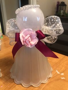 an angel figurine with a pink flower on it