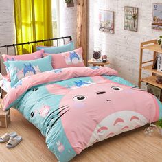 a bed room with a neatly made bed covered in pink and blue comforter sets