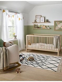 a baby's room with a rocking chair, crib and rugs on the floor