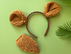 a pair of ears and headbands made out of brown felt on a green surface