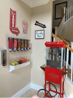 an old fashioned popcorn machine in the corner of a room with signs on the wall