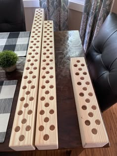 three wooden pegs sitting on top of a table next to a potted plant