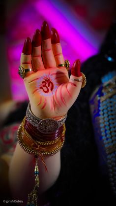 a woman's hand painted with red and white ink holding up her hands in the air