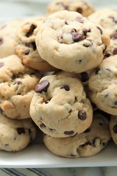 a pile of chocolate chip cookies sitting on top of a white plate