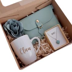 an open box containing a purse, coffee mug and jewelry