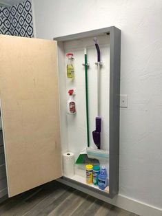 an open cabinet with cleaning supplies in it