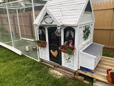 a chicken coop with flowers in the windows