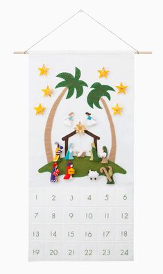 a wall hanging with a nativity scene and palm trees on the calendar for christmas