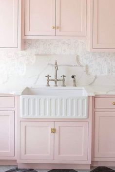 a kitchen with pink cabinets and a white sink