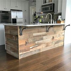 a kitchen with an island made out of wooden planks