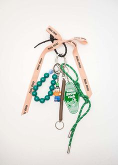 a keychain that has some beads and other items attached to it with a ribbon