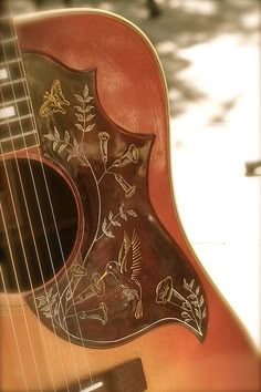 an acoustic guitar is sitting outside on the ground with its fret and strings still attached to it