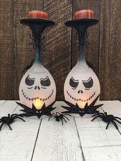 two halloween candlesticks decorated with jack - o'- lantern faces and spider legs