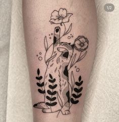 a black and white tattoo of a dog with flowers on it's leg,