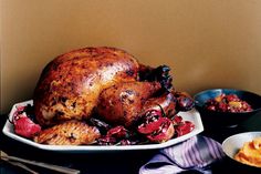 a roasted turkey on a platter with other dishes around it