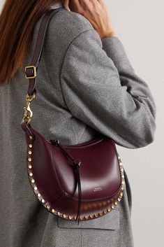 Isabel Marant's 'Oskan Moon' bag is crafted from glossy leather and features a curved shape outlined with gold tone studs. The bag has a matching foiled logo and two pockets inside to keep belongings organized and secure. It can be worn on the shoulder. Expensive Purses, Burgundy Bag, Fall Bags, Moon Studs, Looks Street Style, Mode Inspo, Studded Leather, Fashion Outfit